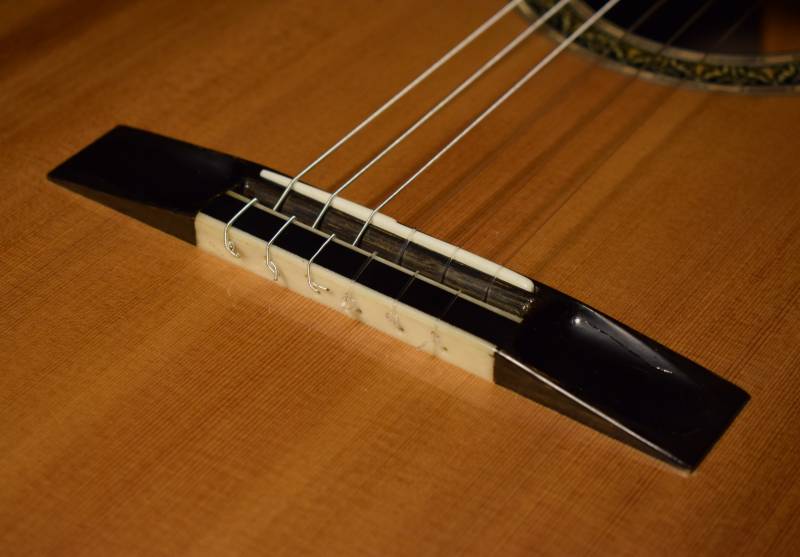 Gilbert style with a bone guard to prevent wear of string holes over time